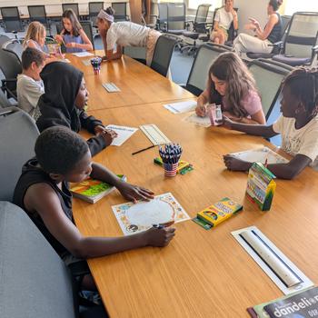 Group of children designing emojis, sitting at a table