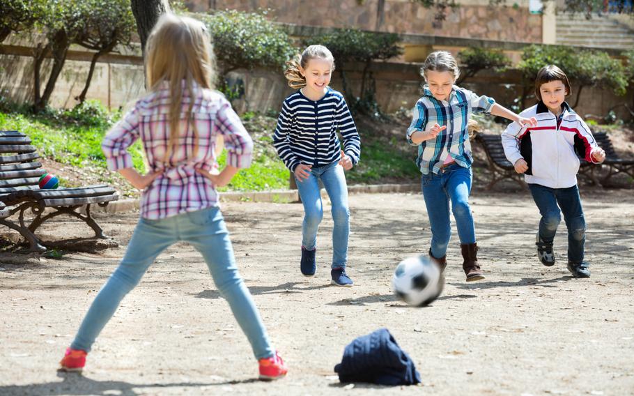 Kids playing soccer with a jacket for the goal