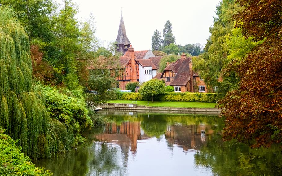 a view across the lake at an old church. weeping willows frame the shot.