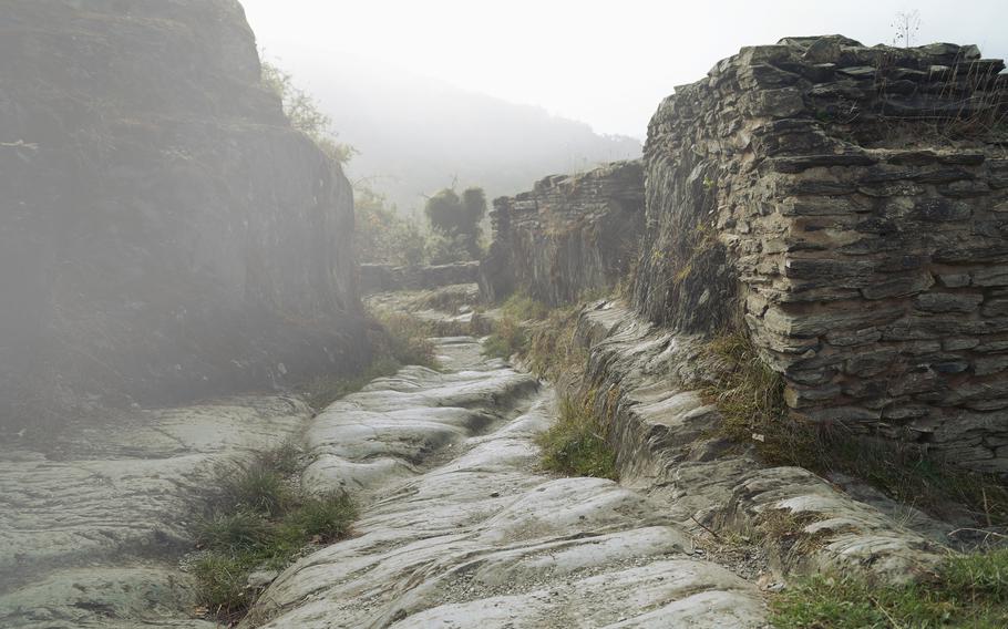 Path in fog. Misty Forest Path. Natural Stone ruin walkway through the Ruins of Schmidtburg. Nostalgic passage through old stone walls of a medieval celtic ruin in Germany, Hunsruck on a foggy day