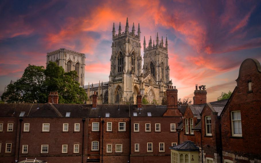 York Minster seen from city walls under a blood red sky behing a red brick building