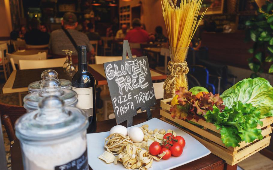 Gluten-free sign and pasta ingredients like fresh tomatoes, eggs and noodles at an Italian restaurant