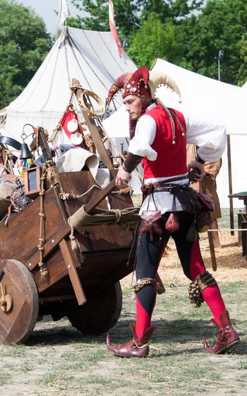 A jester carries around his cart full of props
