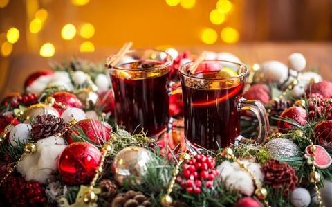 Photo Of Christmas hot mulled wine with spices on a wooden table.