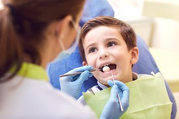 Dentist examining a child’s teeth in the dentists office