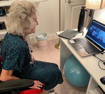 Luke’s Grandmother, a WWII blitz survivor, meeting Parks on the computer. She is facing profile, looking at the computer screen.