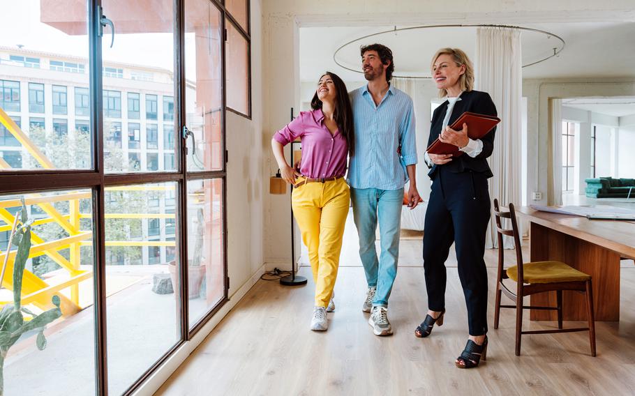 Real estate agent showing a new apartment and features of a good investment to a young couple.