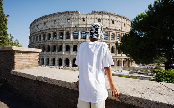 Back of boy tourist enjoy view Colosseum in the old city center of Rome, Italy.