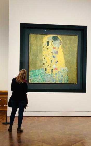 Patron viewing “The Kiss” painting at a museum