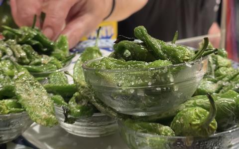 Photo Of Man putting green Pintxos in a clear bowl on counter