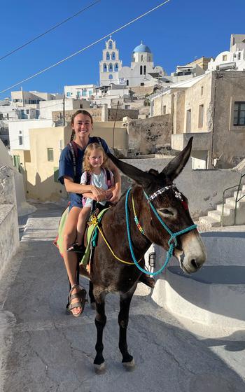 Author and daughter on a donkey smiling at the camera