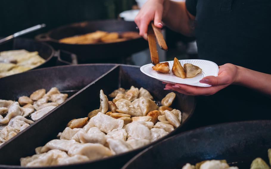 Dumplings with meat, onions on a big cast iron skillet.