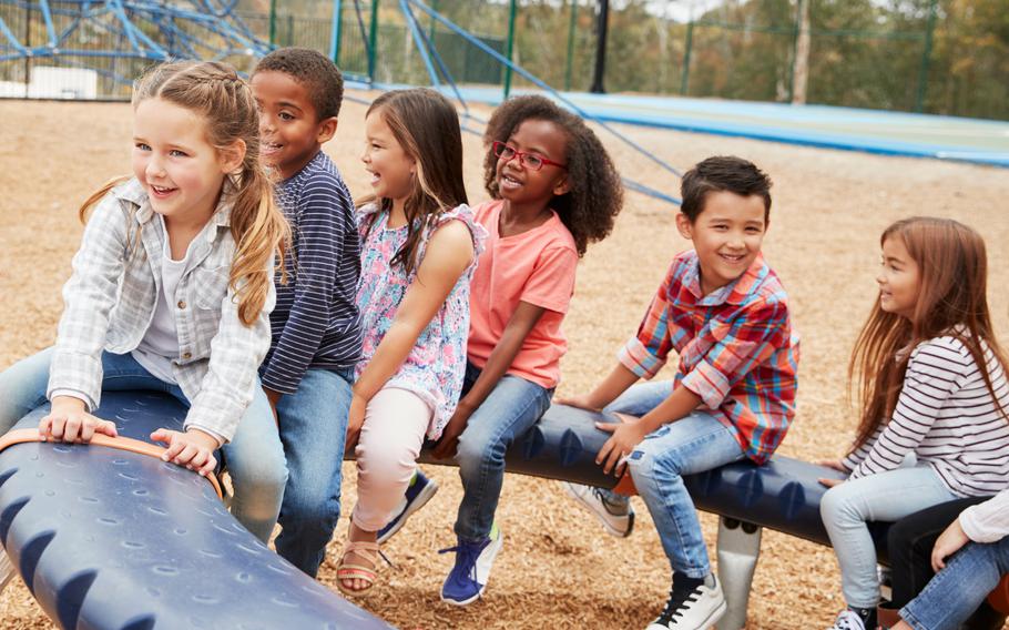 Kids sitting on a spinning carousel in their schoolyard