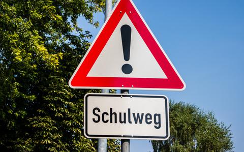 Photo Of Road sign in german language with warning sign on blue sky background