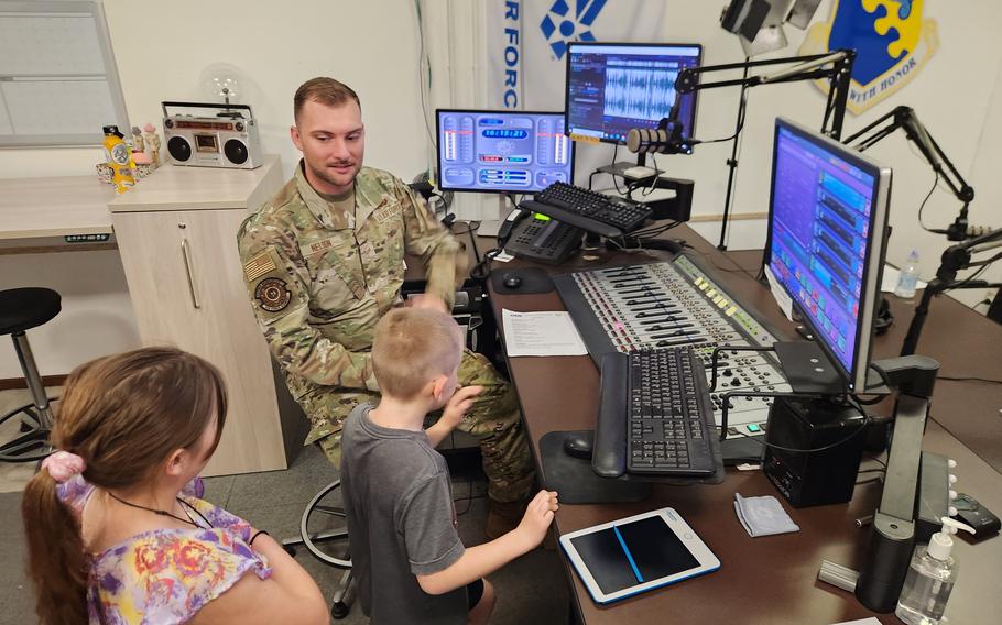 Military-connected kids Zoey and Joey visit with an  AFN radio host during Month of the Military Child.