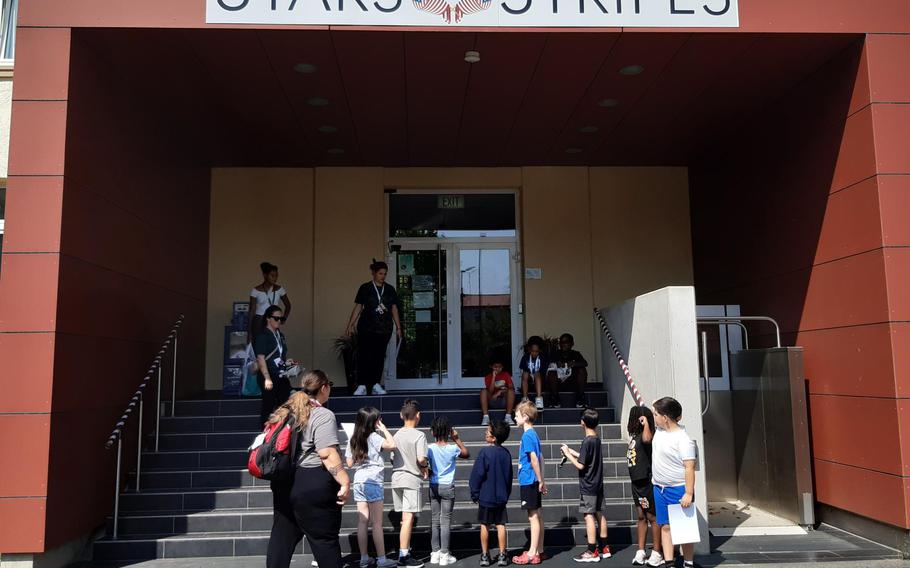 Summer camp children walking up the stairs into the Stars and Stripes building