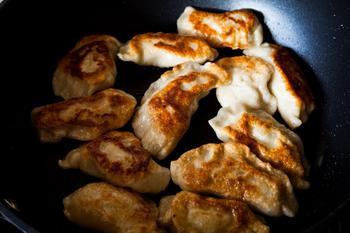 Traditional polish meal pirogi in the frying pan on the table