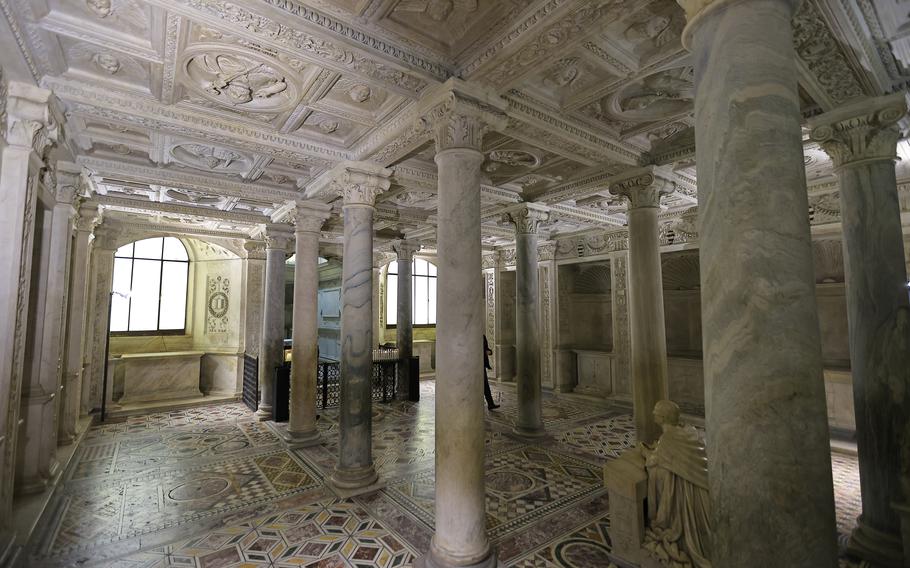 a white and grey marble crypt with doric columns and intricate floor tiles