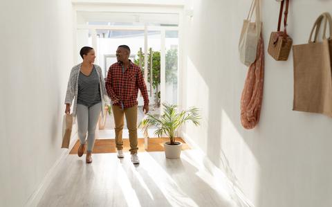 Photo Of African american couple moving in new house. Young man and woman standing in new house and looking at each other