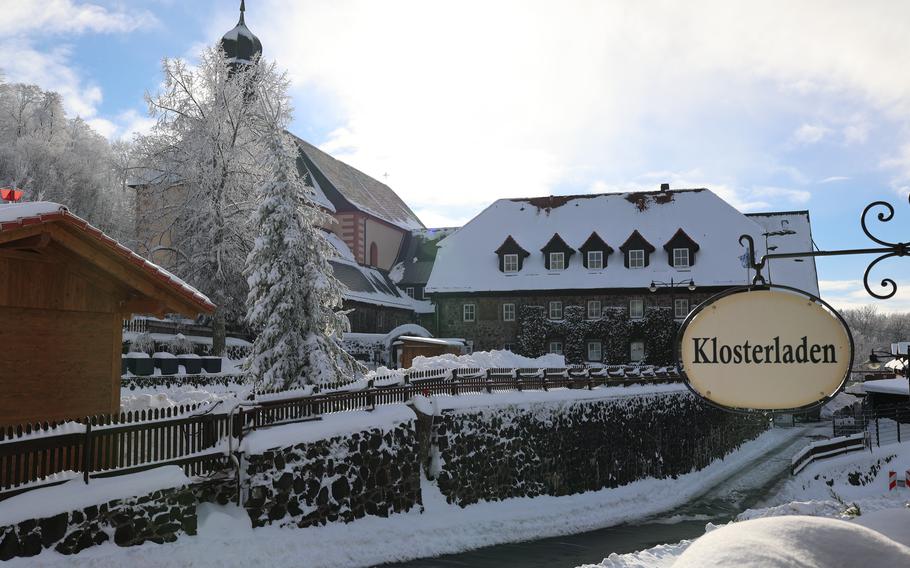 church and monastery building with snow on them and a sign that says Klosterladen.
