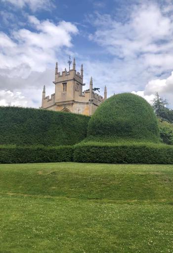 Exterior shot of Sudeley Castle behind large bushes