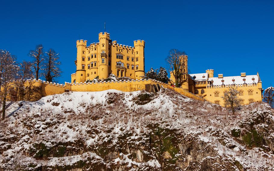 A beautiful yellow castle in the Alps on a lightly snowy landsape