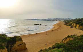 Albufeira, Portugal beach with the sun shining in the left top corner