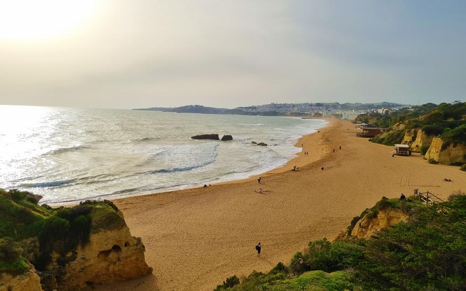 Albufeira, Portugal beach with the sun shining in the left top corner