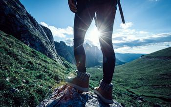 Backpacker hiking on sunset alpine mountain peak