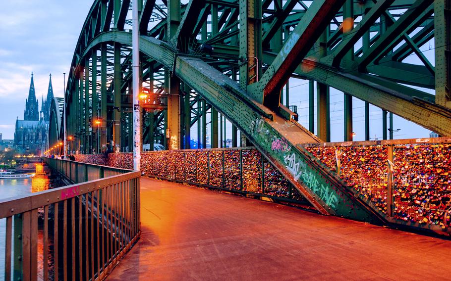 Cologne, Germany. Cloudy day view of Cathedral and illuminated Hohenzollern bridge in Cologne, Germany at night