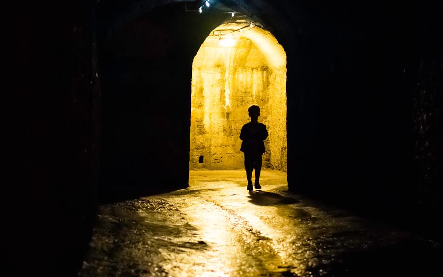 Silhouette of a boy in a dark tunnel. Undeground way under Pula.