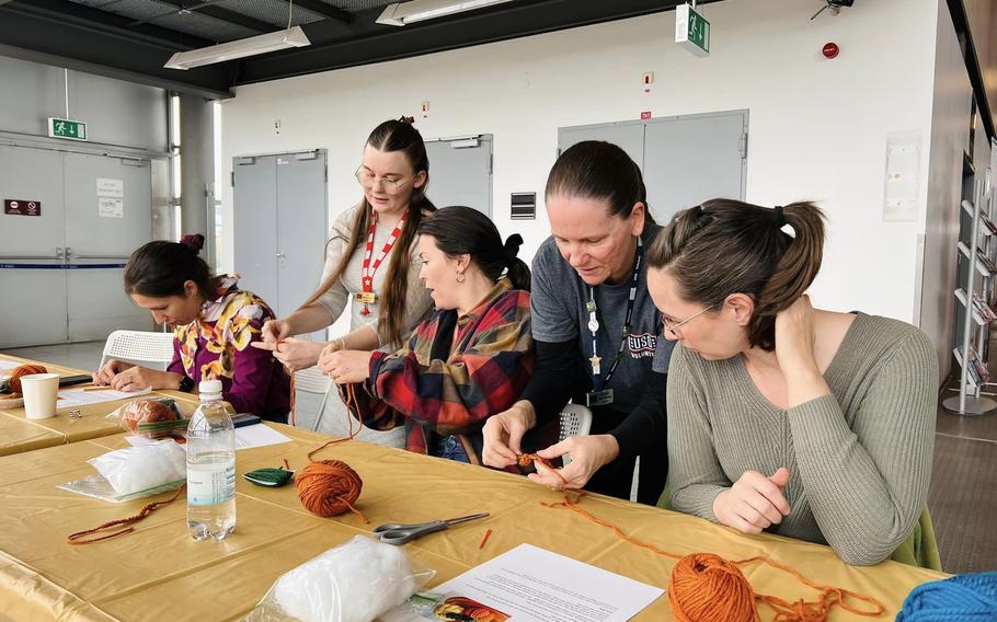 Group looking at instructor crocheting