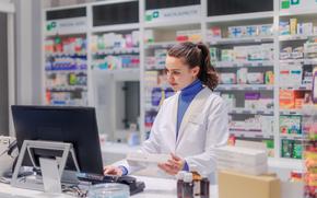 Portrait of a young pharmacist selling medication.