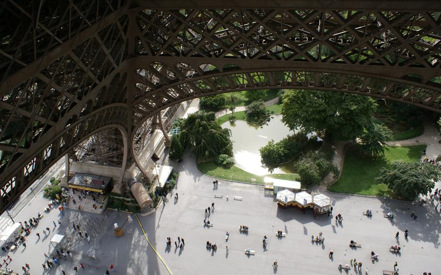 Looking down from inside the Eiffel Tower to a crowd of people 