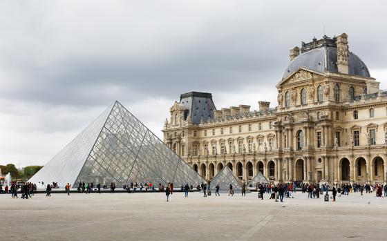 a photo from far away of the louvre and the louvre pyramid