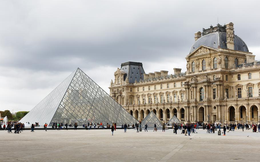 a photo from far away of the louvre and the louvre pyramid