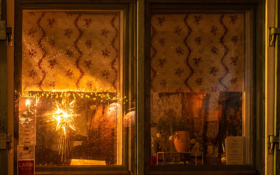 The view of a window from outside on a rainy night with warm light inside and Christmas star near the window