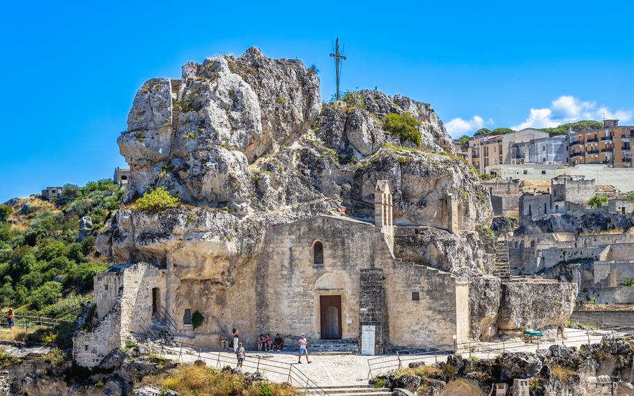 a church is carved into the rock face and caves in Sasso caveoso