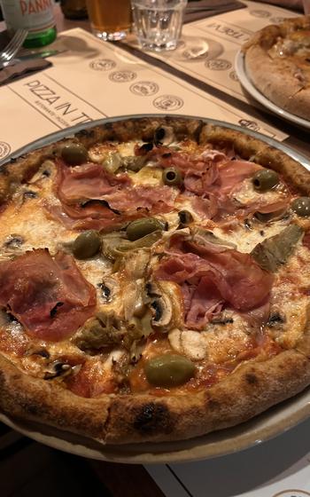 a close-up of a GF pizza with a slightly charred crust 