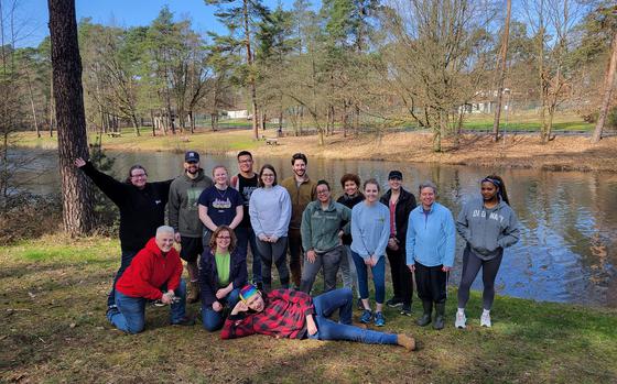 Photo Of Group of volunteers posing together in front of the lake area they just cleaning