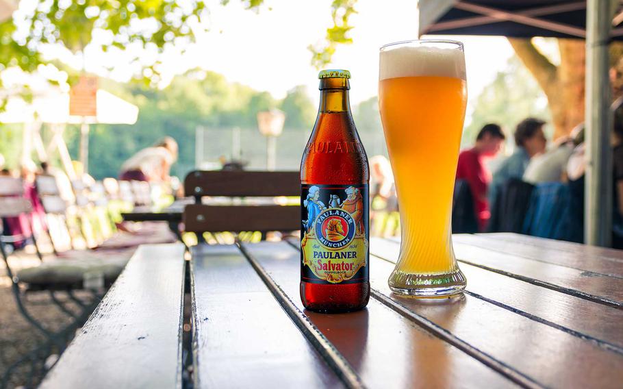 Paulaner Salvator beer bottle on a table with glass at a German beer festival.