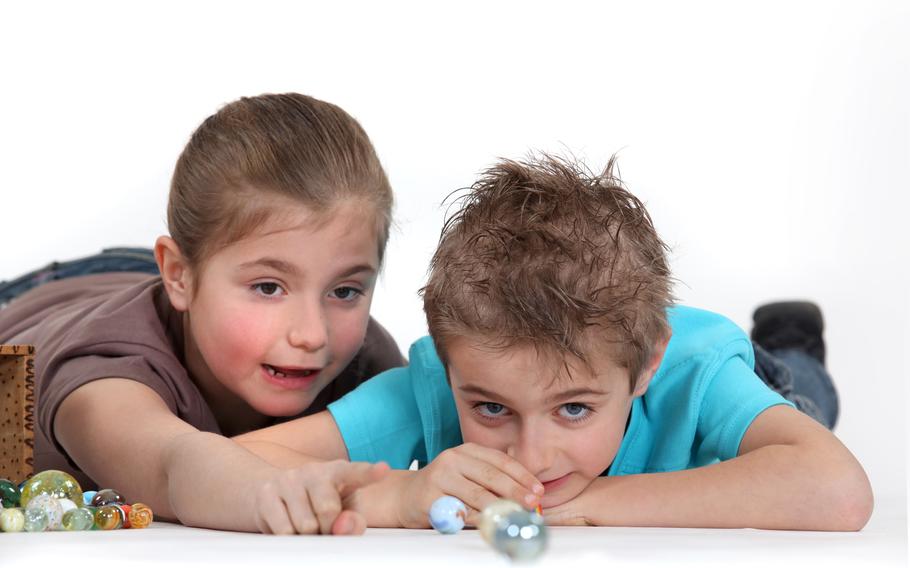 Two kids playing marbles