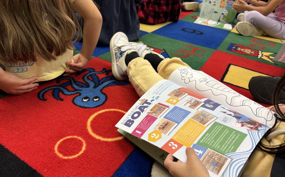 Second-grade student at Ramstein Elementary School library learning about how a magazine like “Dandelions” is created.