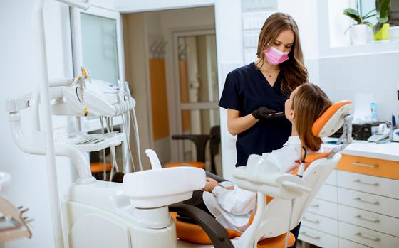 Pretty young woman at oral checkup at the dentist office