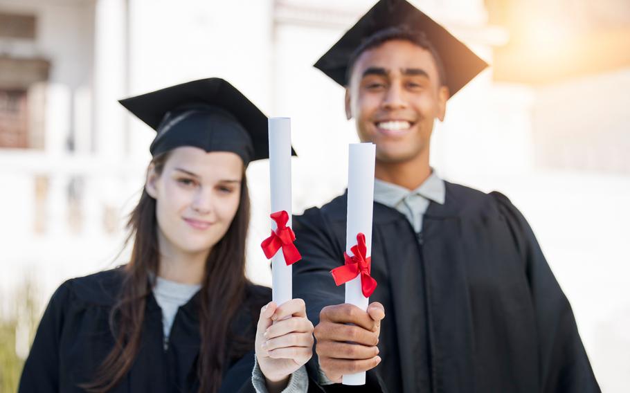 Two students holding certificates