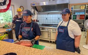 USO volunteers prepping food behind a counter