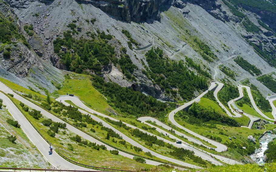 The iconic Passo dello Stelvio road winds through the rugged Italian Alps, with its dramatic hairpin bends and breathtaking mountain scenery, making it a must-see destination for road trip enthusiasts and cyclists.