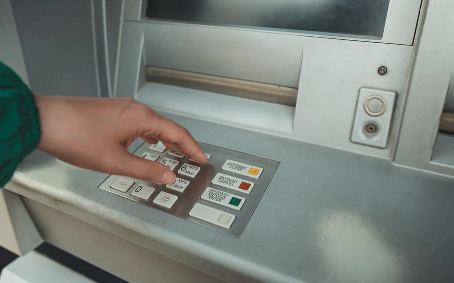 Hand pushing buttons at the ATM