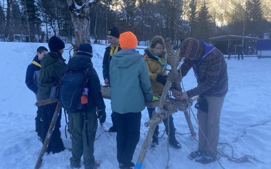 Members of Troop 44 building a wooden structure using rope. That’s what we call a pioneering challenge in the snow.