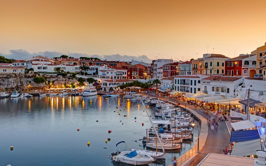 a sunset view of a harbor town with boats still in the water